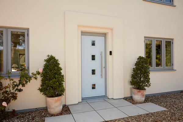 Traditional Composite Front Door Duck egg composite front door with four square glazed panes and a long bar handle, on a rendered home in Bognor Regis